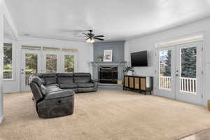 Carpeted living room featuring french doors, ceiling fan, and plenty of natural light