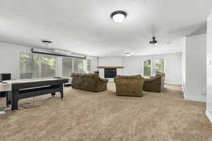 Living room featuring french doors, light colored carpet, a wall mounted air conditioner, and a textured ceiling