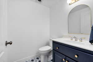 Bathroom with tile floors, toilet, and vanity with extensive cabinet space