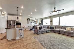 Living room with light hardwood / wood-style flooring and ceiling fan