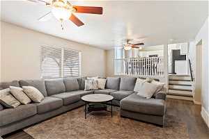 Living room featuring dark hardwood / wood-style flooring, ceiling fan, and plenty of natural light