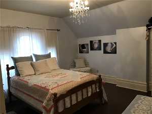 Bedroom with vaulted ceiling and a chandelier