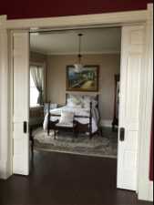 Bedroom with dark hardwood / wood-style flooring and ornamental molding
