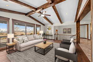 Living room featuring vaulted ceiling with beams, light hardwood / wood-style flooring, and ceiling fan