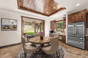 Dining space with a raised ceiling and wooden ceiling