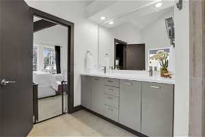 Bathroom with dual sinks, lofted ceiling, and large vanity