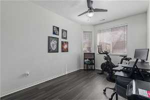 Office with dark hardwood / wood-style flooring and ceiling fan
