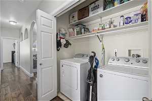 Laundry area with separate washer and dryer and dark hardwood / wood-style floors