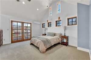 Carpeted bedroom featuring high vaulted ceiling, access to exterior, and a wall mounted AC