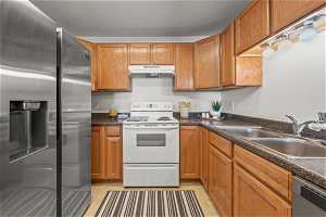 Kitchen with sink, appliances with stainless steel finishes, and light tile floors