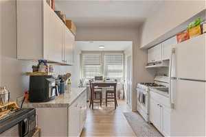 Unit 1006 - Kitchen featuring white appliances and white cabinetry