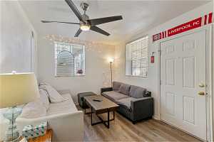 Unit 1002 - Living room featuring light hardwood / wood-style floors and ceiling fan