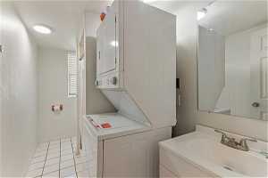 Unit 1004 - Bathroom with vanity, stacked washer and dryer, and tile flooring