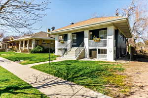 View of front of home with a front yard and a porch