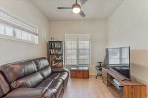 Unit 1004 - Living room featuring ceiling fan and light wood-type flooring