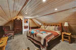 Bedroom featuring vaulted ceiling, light carpet, and wooden ceiling