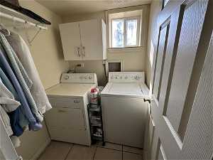 Laundry room featuring hookup for a washing machine, washing machine and dryer, and cabinets.