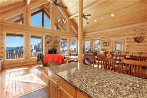 Kitchen with high vaulted ceiling, plenty of natural light, stone countertops, and a fireplace