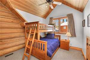 Carpeted bedroom featuring lofted ceiling, ceiling fan, rustic walls, and wood ceiling