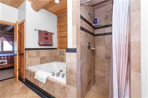 Bathroom with wood ceiling, tile floors, and separate shower and tub