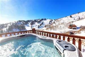 Snow covered pool featuring an outdoor hot tub