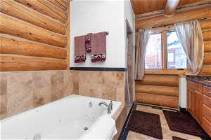 Bathroom featuring rustic walls, tile walls, vanity, wooden ceiling, and tile flooring