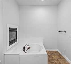 Bathroom with tile flooring and a washtub