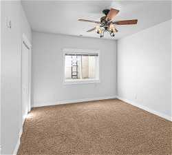Unfurnished room featuring ceiling fan and carpet flooring