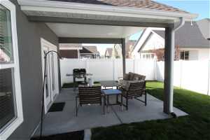 View of covered patio featuring grilling area and an outdoor hangout area
