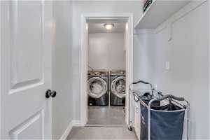 Laundry area with light carpet and washing machine and clothes dryer