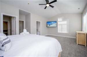 Master bedroom featuring light carpet, vaulted ceiling, ceiling fan, and multiple windows