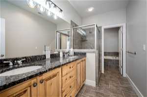 Master bathroom featuring tile flooring, separate shower and tub, and dual bowl vanity