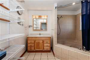 Owner's suite Full Bathroom featuring tiled shower / bath combo, tile flooring, and vanity.