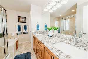 Bathroom with double sink, shower with separate bathtub, tile flooring, and large vanity