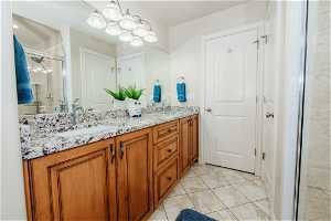 Bathroom featuring tile flooring, dual sinks, a chandelier, and large vanity