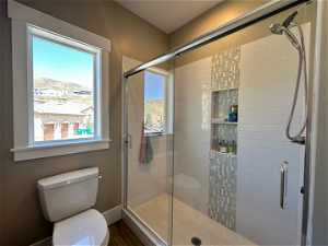 Bathroom with a shower with shower door and toilet