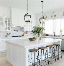 Kitchen with white cabinets, a kitchen island, and a breakfast bar