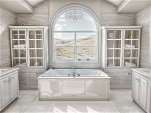 Bathroom with a bath, vanity, tile walls, and an inviting chandelier