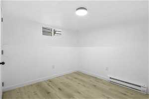 Unfurnished room featuring light hardwood / wood-style flooring and baseboard heating