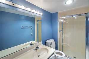Bathroom with walk in shower, oversized vanity, and toilet