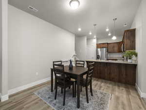 Dining area featuring sink, light hardwood / wood-style floors, and a textured ceiling