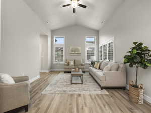 Living room featuring light wood-type flooring, ceiling fan, and lofted ceiling