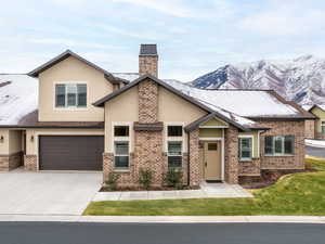 View of front of home with a mountain view and a garage