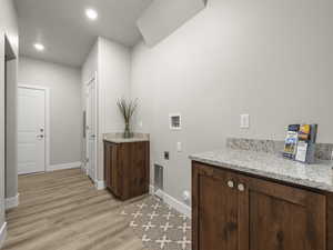 Washroom featuring hookup for an electric dryer, washer hookup, and light hardwood / wood-style floors