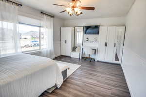 Bedroom featuring ceiling fan, dark hardwood / wood-style flooring, and a textured ceiling