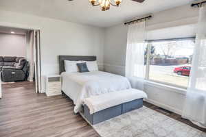 Bedroom with a notable chandelier and hardwood / wood-style flooring