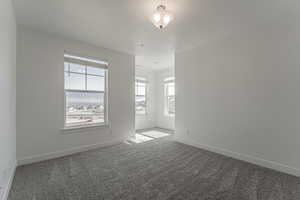 Empty room featuring a textured ceiling and carpet flooring