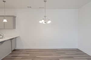 Unfurnished dining area with light hardwood / wood-style flooring and an inviting chandelier