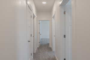 Corridor with light colored carpet