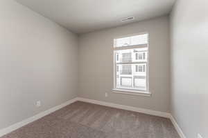 Unfurnished room featuring carpet and a textured ceiling